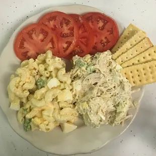 Chicken salad plate with macaroni salad and sliced tomatoes
