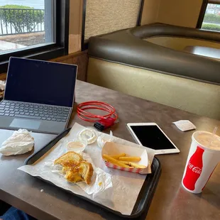 a tray of food and a laptop on a table