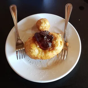 Fried biscuit stuffed with cream cheese and topped with plum jelly