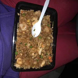 a tray of fried rice with a spoon