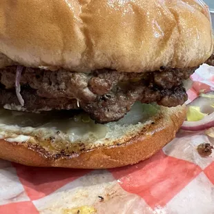 a hamburger with meat and onions