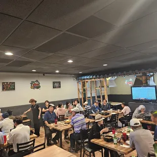 a large group of people sitting at tables in a restaurant