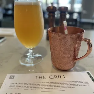 a glass of beer and a copper mug