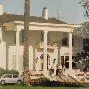 a large white house with a car parked in front of it