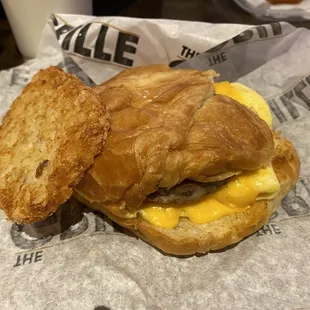 Breakfast sandwich. Sausage egg and cheese on a croissant a Mickie D&apos;s style hash brown.