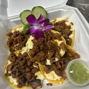 a plate of tacos with sauce and cucumbers