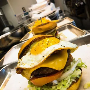 two burgers with fried eggs and lettuce