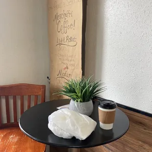 a table with a cup of coffee and a napkin on it