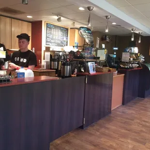 a man behind the counter of a coffee shop