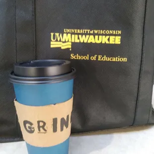 a cup of coffee next to a bag