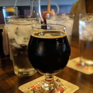 a glass of beer on a coaster