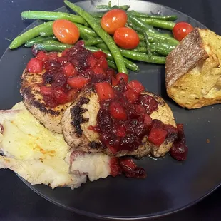 Pork dolce. Pork topped with cranberry apple compote. Served with toasted bread, smashed potatoes, and green beans. All delicious!