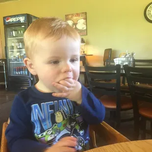 a young boy sitting at a table in a restaurant