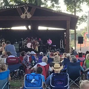 a large crowd of people sitting in lawn chairs