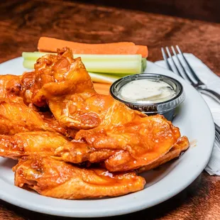 a plate of buffalo wings and celery