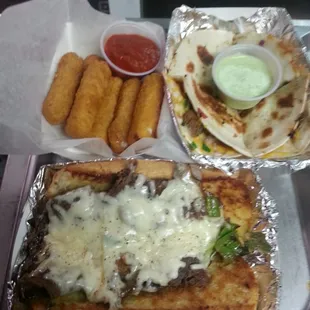 a tray of food including a sandwich, fries, and dip sauce