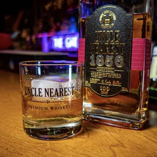 a glass of whiskey next to a bottle