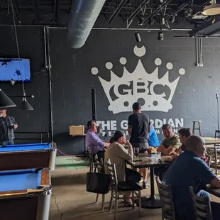 people sitting at tables with pool tables