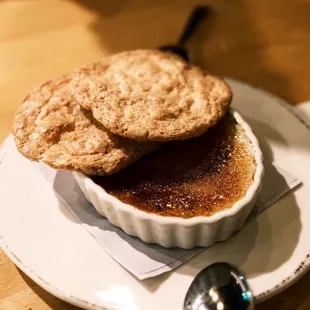 a plate of creme with two cookies on top