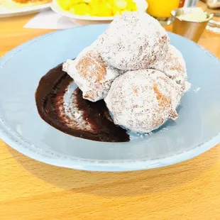 a plate of donuts with chocolate sauce