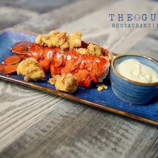 a plate of lobsters with a dipping sauce