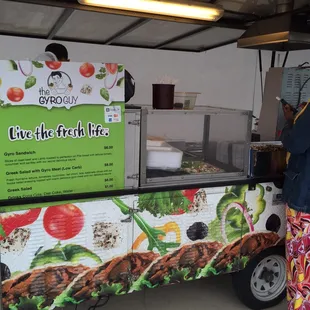 a woman standing in front of a food truck