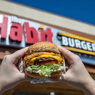 a person holding a hamburger