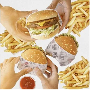 hands holding burgers and french fries