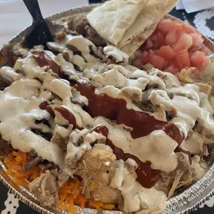 The regular plate combination with Beef and Chicken, rice, lettuce, tomato, white sauce, a little hot sauce and naan bread