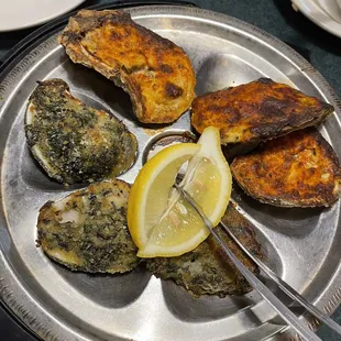 a plate of oysters with a slice of lemon