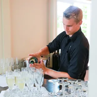 Bartender serving sparkling wine in the Vashon Room. Photo by George Street Photo.