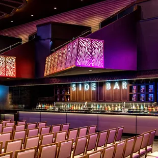 rows of chairs in front of a bar