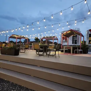 a patio with seating and string lights