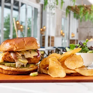 a sandwich and chips on a cutting board