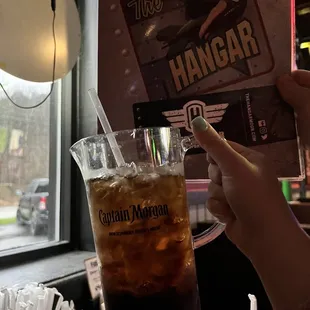 a person holding a glass of ice tea