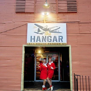 a man in a red suit standing in front of the hangar hangar