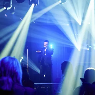 a man in a tuxedo speaking into a microphone