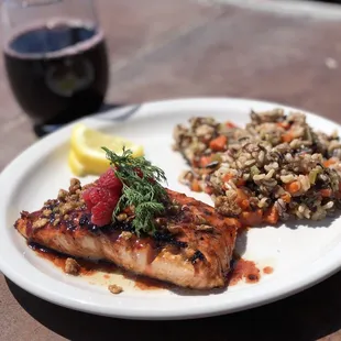 Grilled Salmon topped with a raspberry glaze, served with wild rice pilaf.