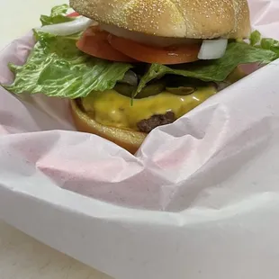 Burger with cheese, tomato, lettuce, onion, jalapeños, and mushrooms