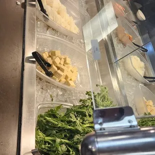 a variety of salads in a display case