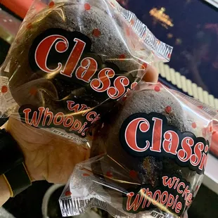 a close up of a person's hand holding two bags of clams