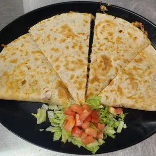 a quesadilla with lettuce and tomatoes
