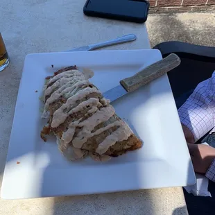 a person sitting at a table with a knife and a plate of food