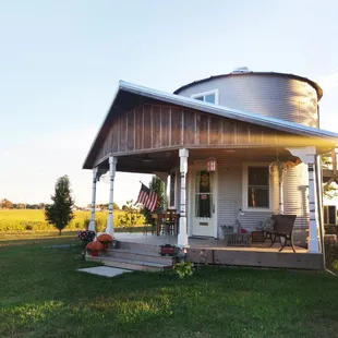 The front porch with table for outdoor dining and a long church pew for lounging and looking at the sunrise.