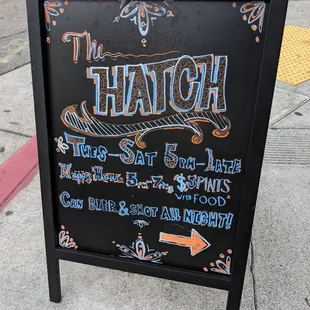 a chalkboard sign on a sidewalk