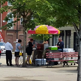 a group of people standing on a sidewalk