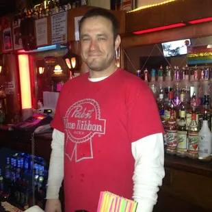 a man standing behind a bar