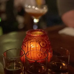 two glasses of whiskey and a candle