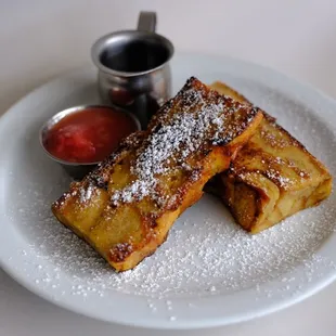 a plate of french toast with powdered sugar