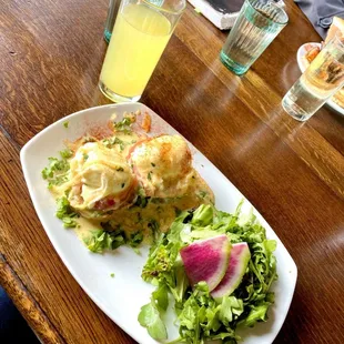 Eggs benedict with tomato and side salad
